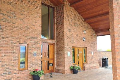 Gedling Crematorium main entrance doors with waiting to the right